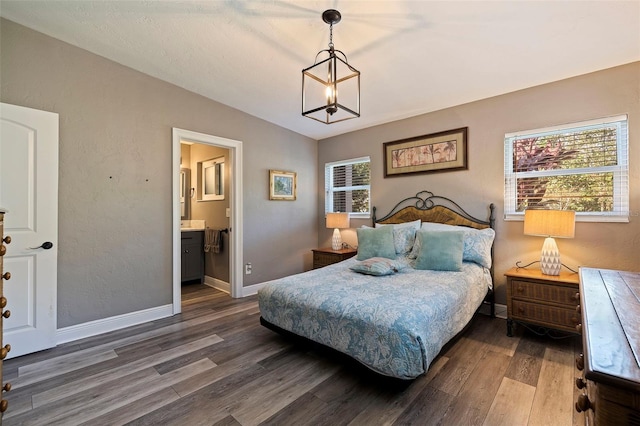 bedroom featuring connected bathroom, dark hardwood / wood-style floors, vaulted ceiling, and multiple windows