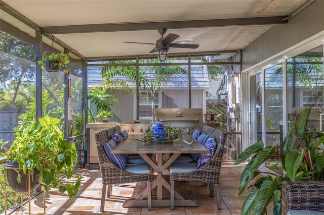 sunroom / solarium featuring beamed ceiling, ceiling fan, and a healthy amount of sunlight