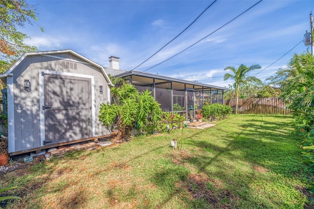 view of yard featuring a sunroom and a storage unit