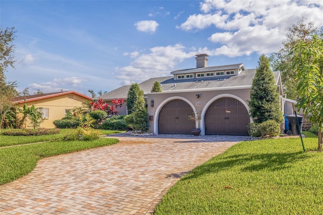 mediterranean / spanish home featuring a front yard and a garage