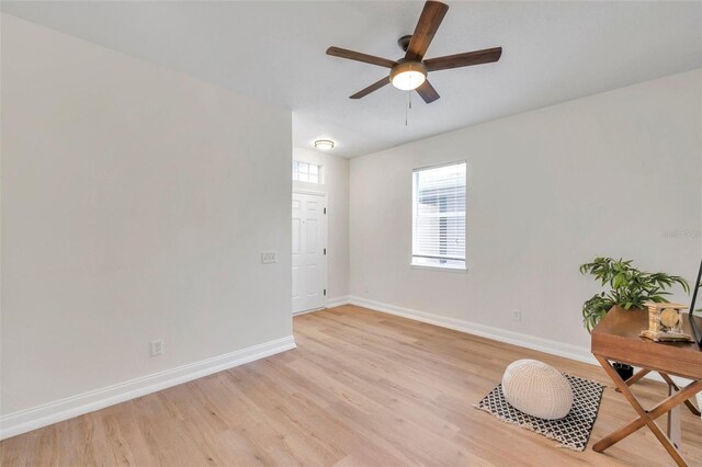 empty room with ceiling fan and light hardwood / wood-style flooring