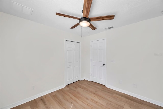 spare room featuring a textured ceiling, light wood-type flooring, and ceiling fan