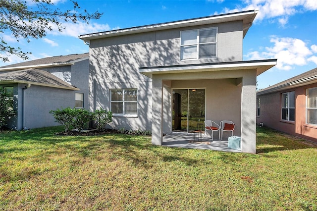 rear view of house featuring a patio area and a yard