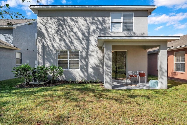 back of property featuring a yard and a patio