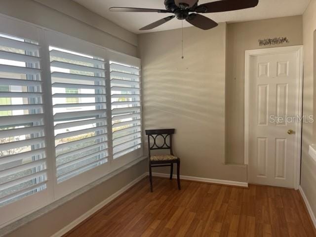 sitting room with hardwood / wood-style floors and ceiling fan