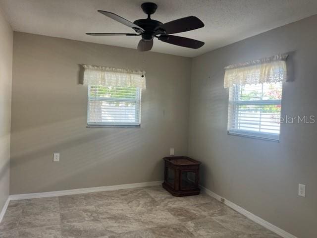 unfurnished room with a wealth of natural light and ceiling fan