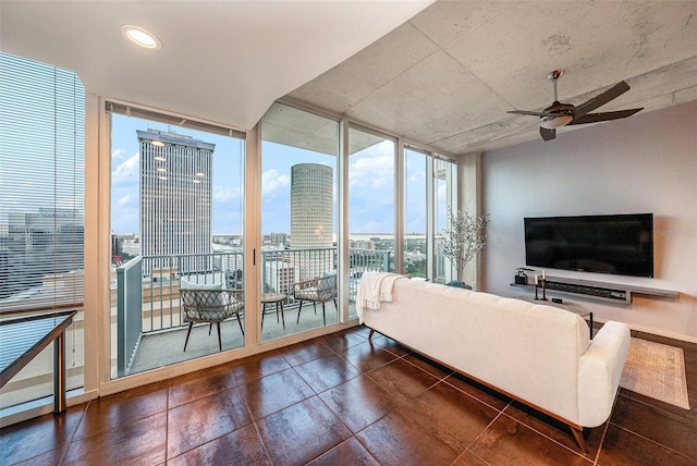 living room with ceiling fan and a wall of windows