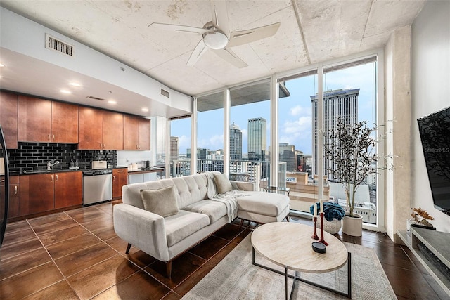 living room featuring floor to ceiling windows, ceiling fan, and sink