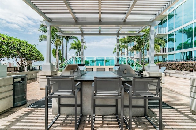 view of patio / terrace featuring a pergola, area for grilling, and exterior kitchen