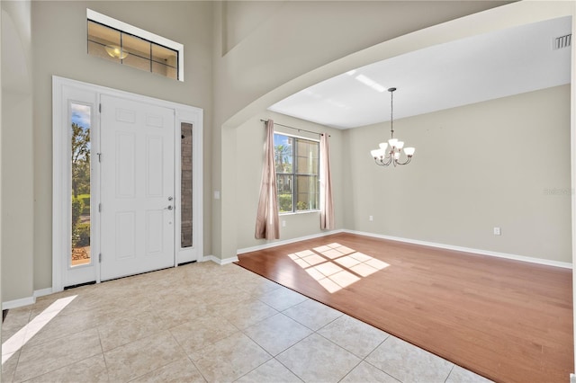 entrance foyer with light hardwood / wood-style flooring and an inviting chandelier