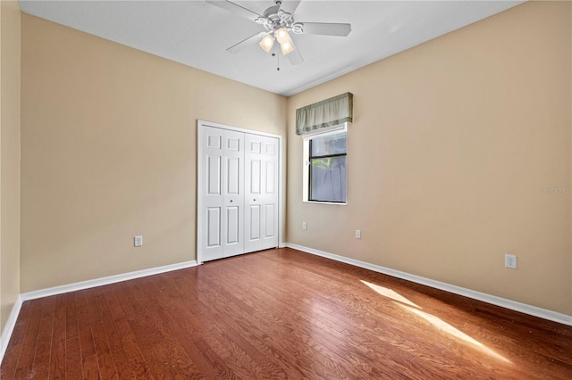 unfurnished bedroom featuring a closet, hardwood / wood-style flooring, and ceiling fan