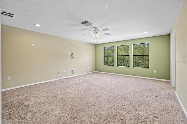 carpeted spare room featuring ceiling fan and a textured ceiling