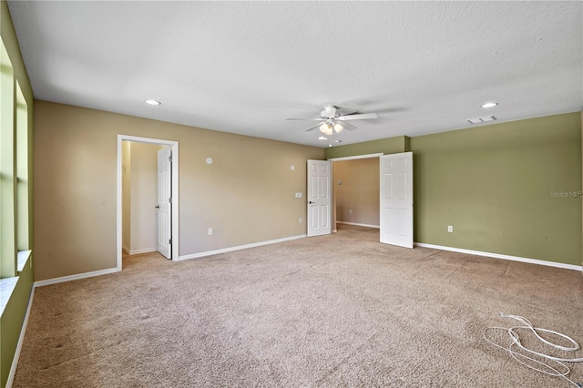 empty room featuring ceiling fan, carpet, and a textured ceiling