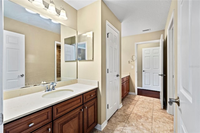 bathroom featuring vanity, a textured ceiling, and tile patterned floors