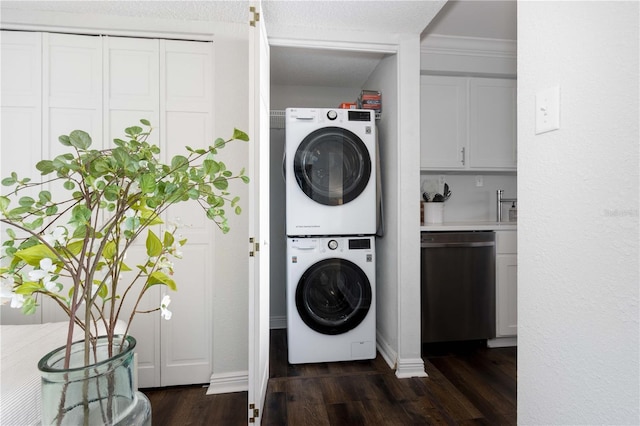 laundry room with dark wood-type flooring, stacked washer and dryer, ornamental molding, and a textured ceiling