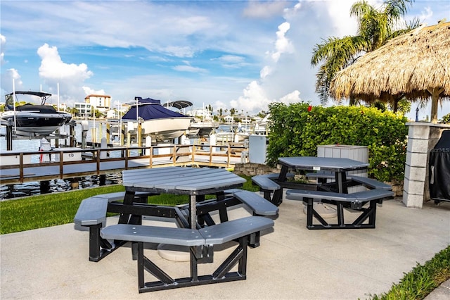 view of patio with a water view and a dock