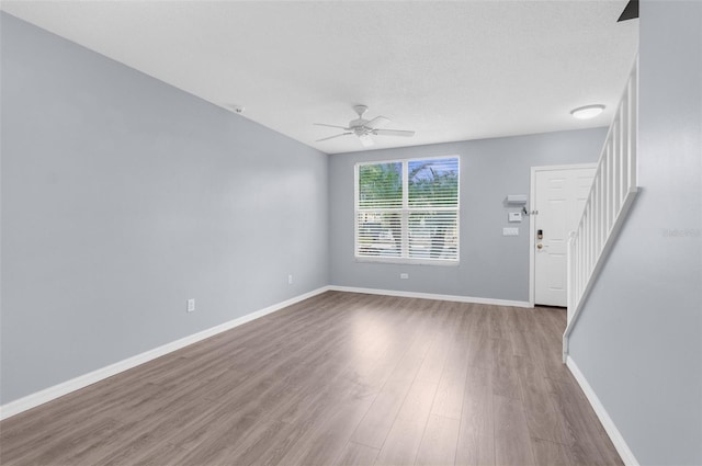 interior space with ceiling fan, a textured ceiling, and hardwood / wood-style flooring