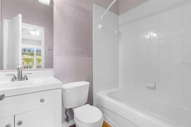 full bathroom with vanity, tiled shower / bath combo, and toilet