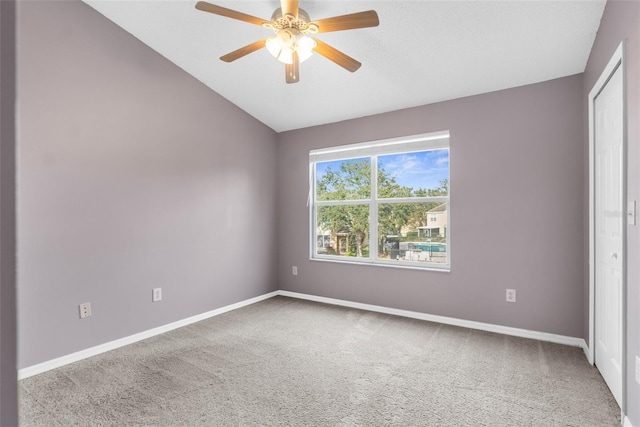 carpeted spare room featuring ceiling fan and lofted ceiling