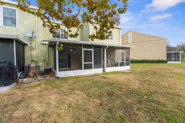 rear view of property featuring a yard and central AC