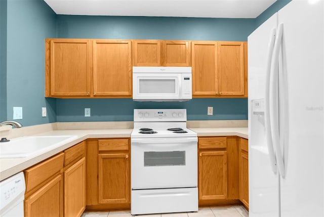 kitchen featuring light tile patterned floors, white appliances, and sink