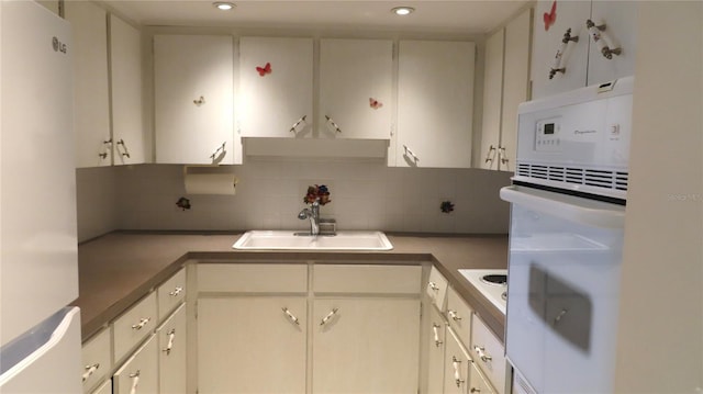 kitchen with backsplash, sink, and white appliances