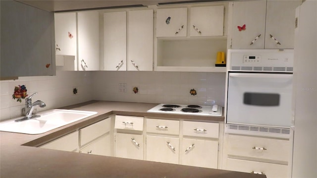 kitchen featuring sink, decorative backsplash, white cabinets, and white appliances