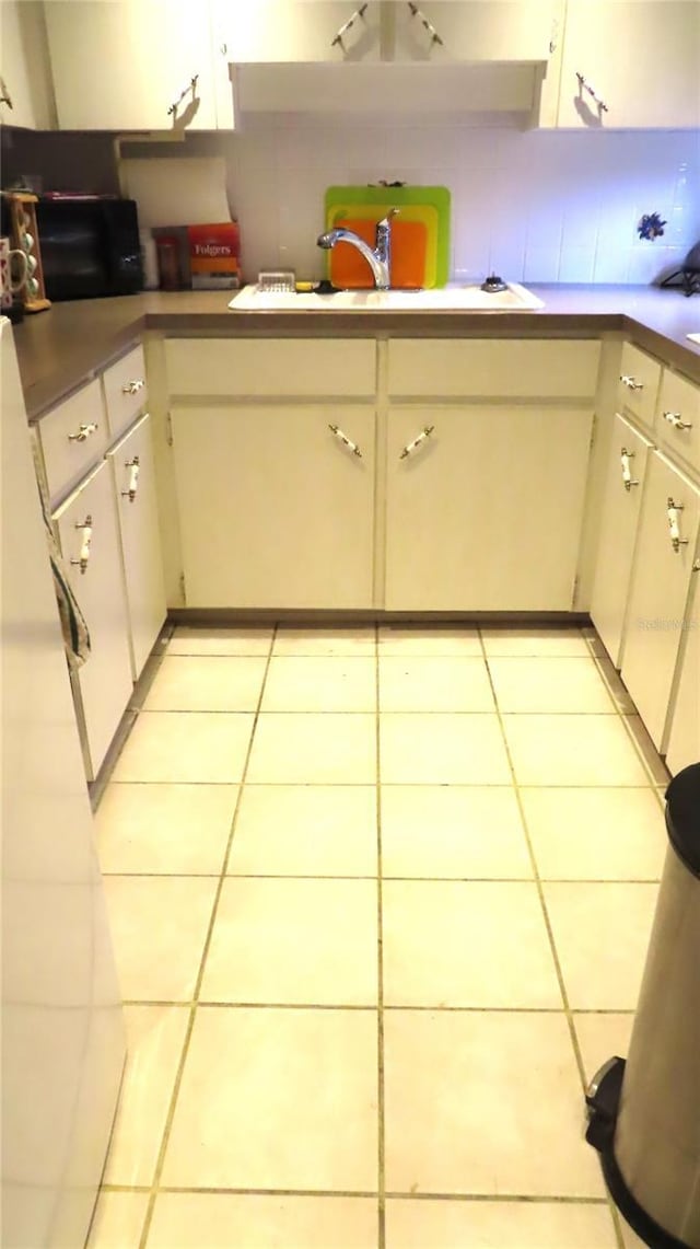 kitchen featuring light tile patterned floors, backsplash, and sink