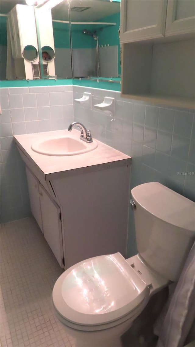 bathroom featuring tile walls, tile patterned floors, and vanity