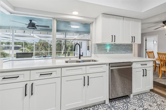 kitchen with light wood-type flooring, stainless steel dishwasher, ceiling fan, sink, and white cabinetry