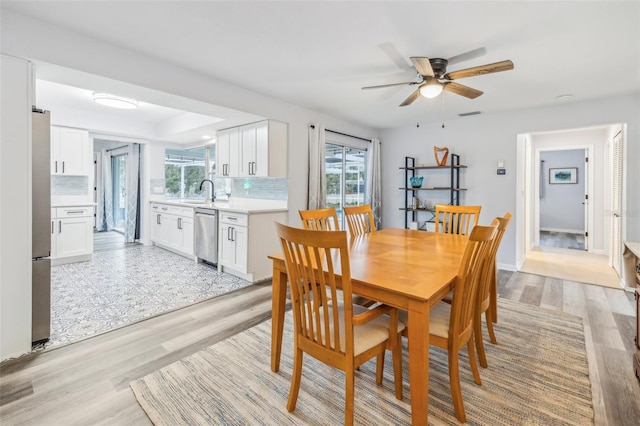 dining area with ceiling fan, sink, a healthy amount of sunlight, and light wood-type flooring