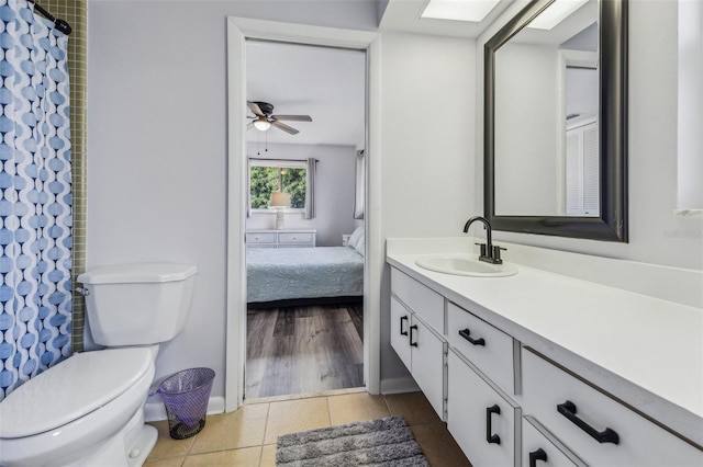 bathroom with ceiling fan, tile patterned flooring, toilet, vanity, and a shower with shower curtain