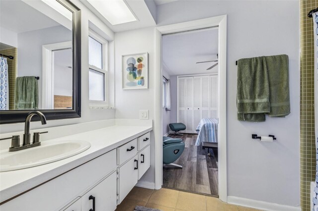 bathroom with hardwood / wood-style floors, vanity, and ceiling fan