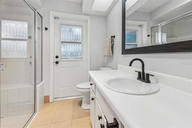 bathroom with tile patterned floors, toilet, vanity, and walk in shower