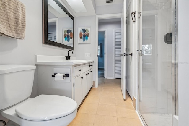 bathroom featuring toilet, vanity, tile patterned floors, and an enclosed shower