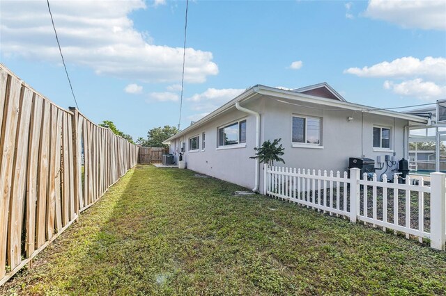 view of home's exterior featuring a lawn and central AC