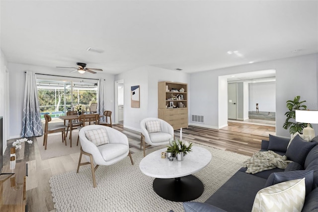 living room with light hardwood / wood-style flooring and ceiling fan