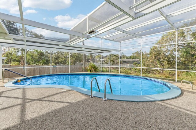 view of pool featuring glass enclosure and a patio area