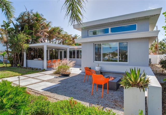 rear view of house featuring a patio, an outdoor fire pit, and exterior bar