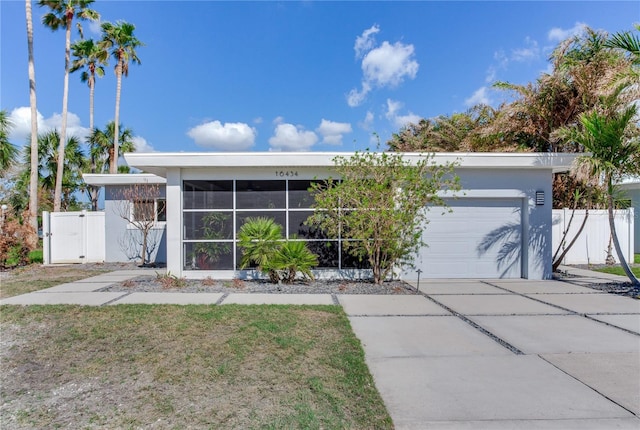 view of front of home featuring a garage and a sunroom