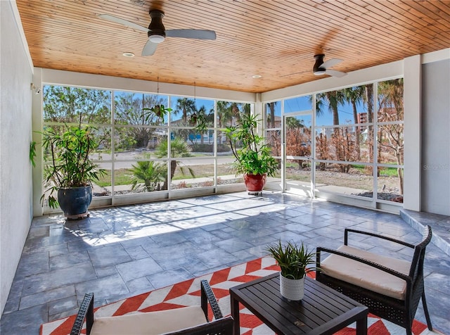 exterior space featuring glass enclosure and ceiling fan