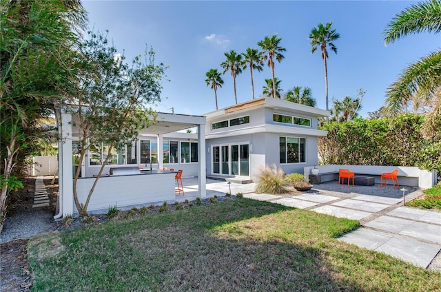 rear view of property with a lawn and a patio