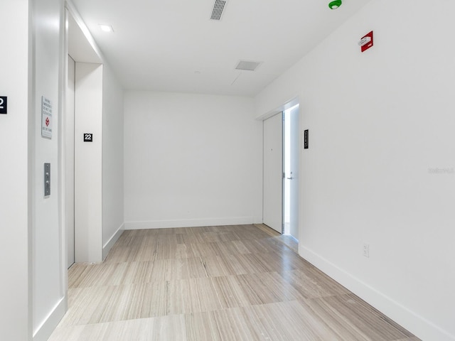 hallway with light hardwood / wood-style floors