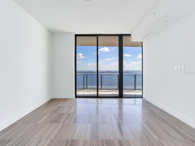 2912 W Santiago St Unit 2204, Tampa, FL 33629 - empty room with floor to ceiling windows, a water view, wood finished floors, and baseboards