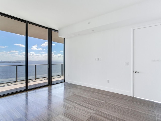 empty room featuring a water view and floor to ceiling windows