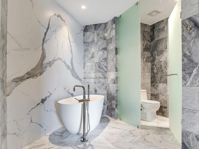 bathroom with a bath, toilet, and tile walls