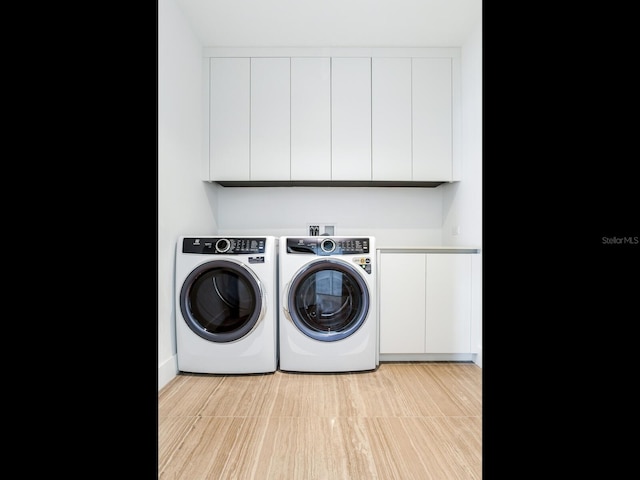 washroom featuring cabinets, light wood-type flooring, and washer and clothes dryer