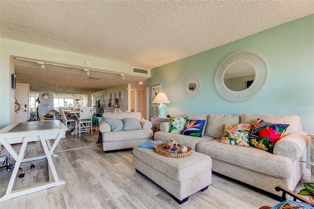 living room featuring wood-type flooring and a textured ceiling