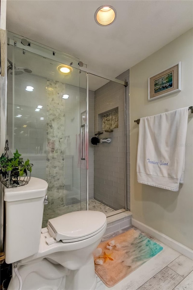 bathroom with toilet and a shower with door