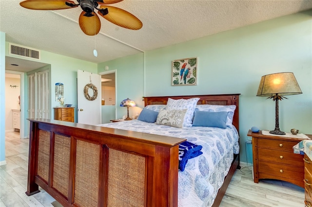 bedroom with ceiling fan, a textured ceiling, and light wood-type flooring